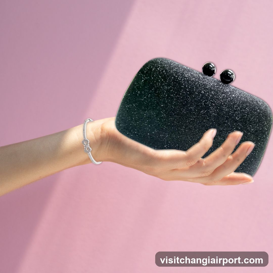 Hand holding a black clutch bag