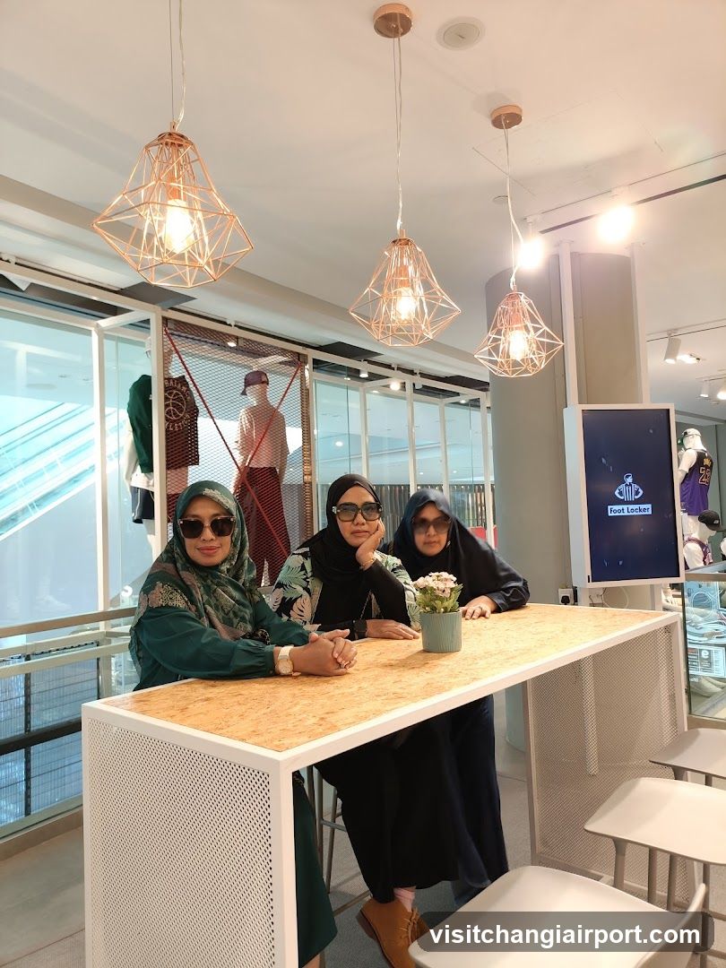 Three women at a modern bar table in a mall