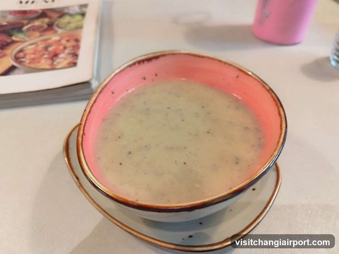 Bowl of creamy soup with pink interior bowl