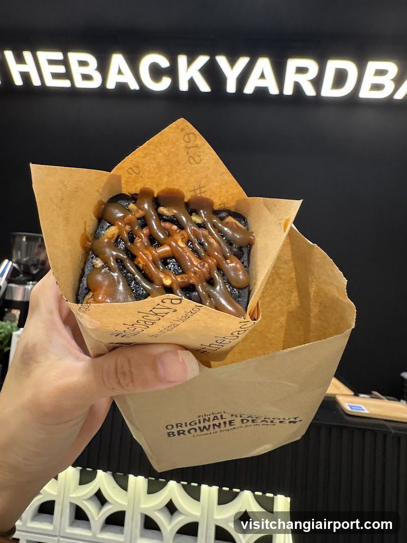 Hand holding a brownie with caramel drizzle