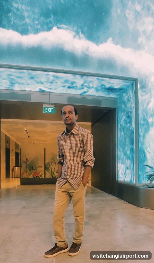 Man standing in a modern interior with sky-themed ceiling