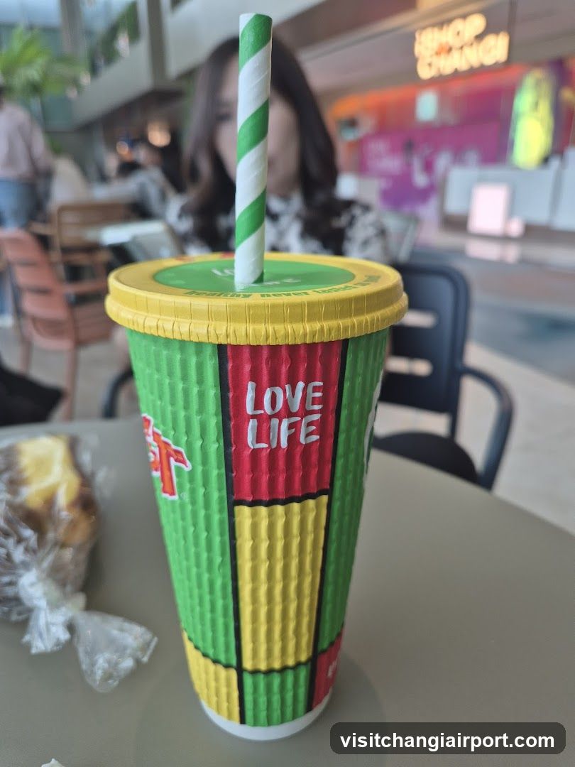 Rasta-themed drink cup with straw and food on table