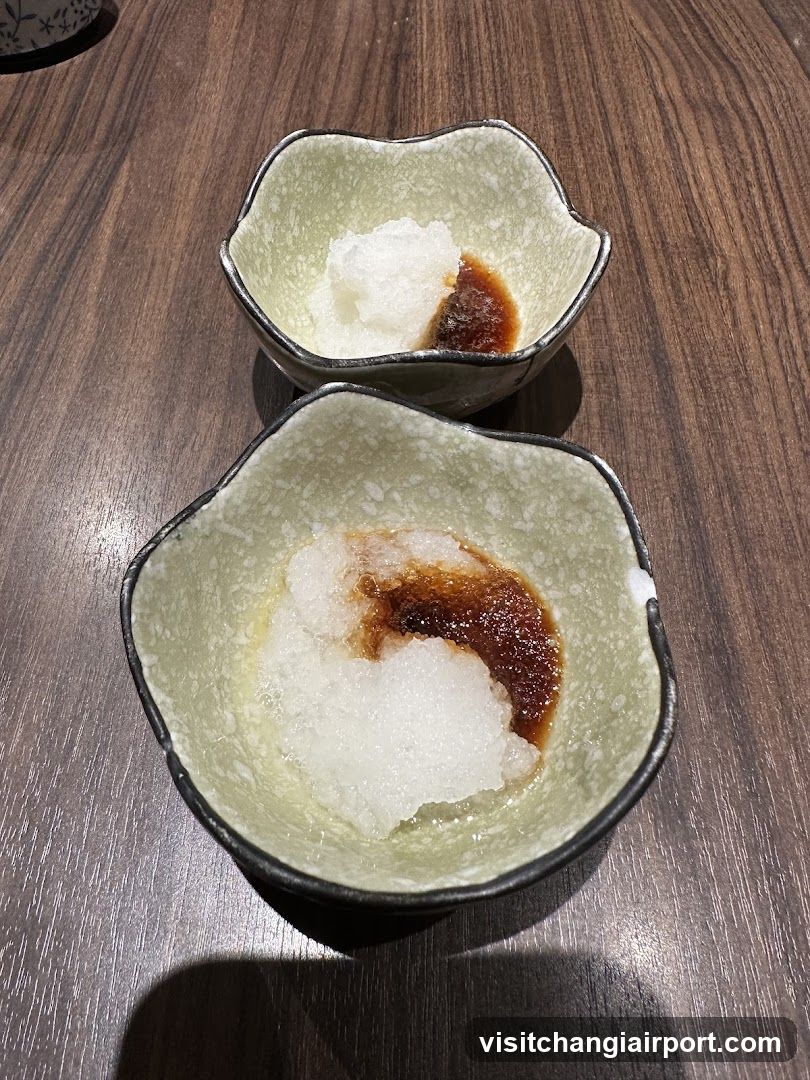 Two small ceramic bowls with condiments on a wooden table