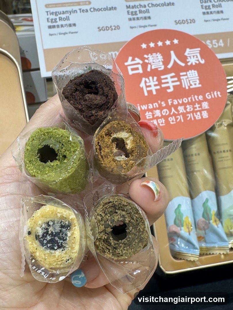 Hand holding assorted egg rolls with price list in background