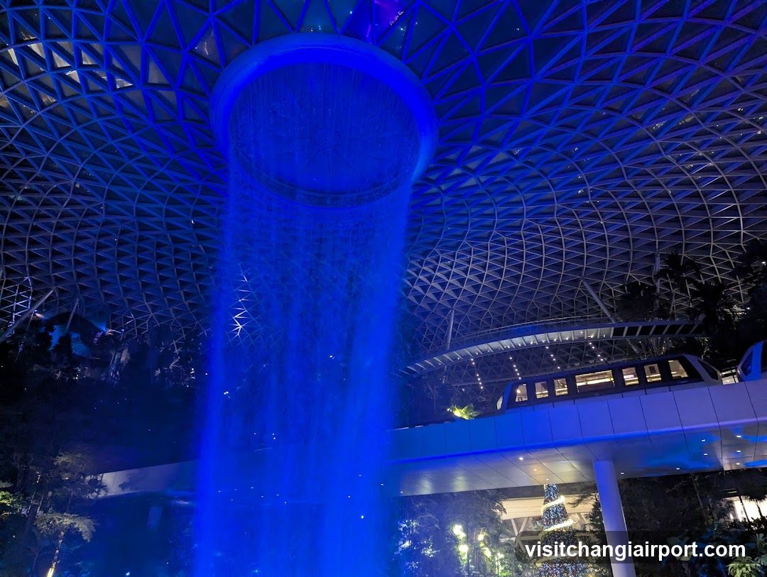 Blue-lit indoor waterfall scene