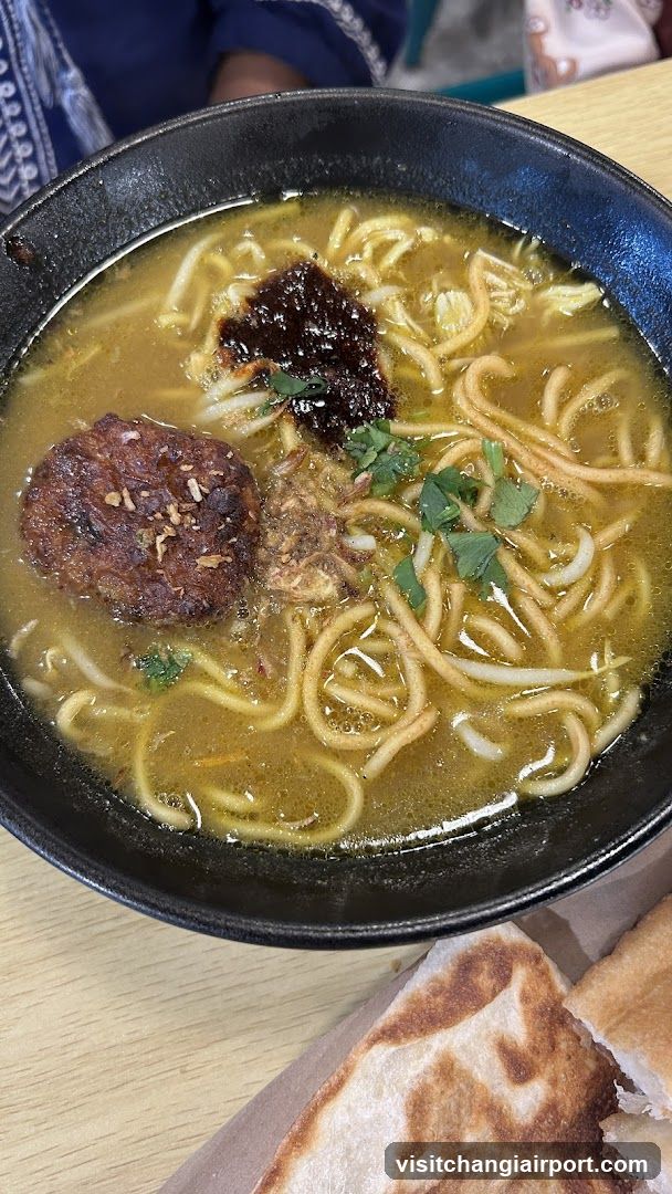 Bowl of Noodle Soup with Meatball and Bread