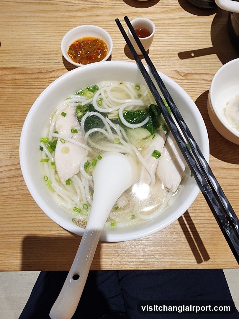 Bowl of Noodle Soup with Chopsticks and Sauce Dishes