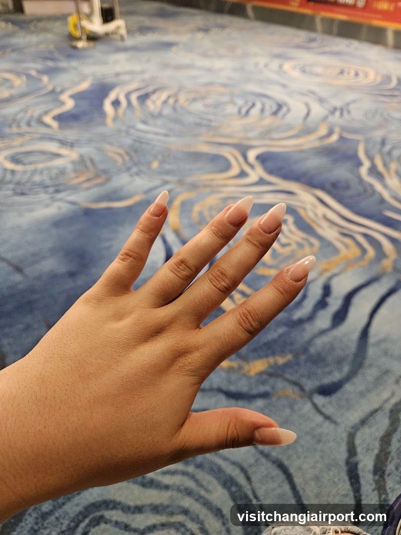 Hand with manicured nails on patterned carpet