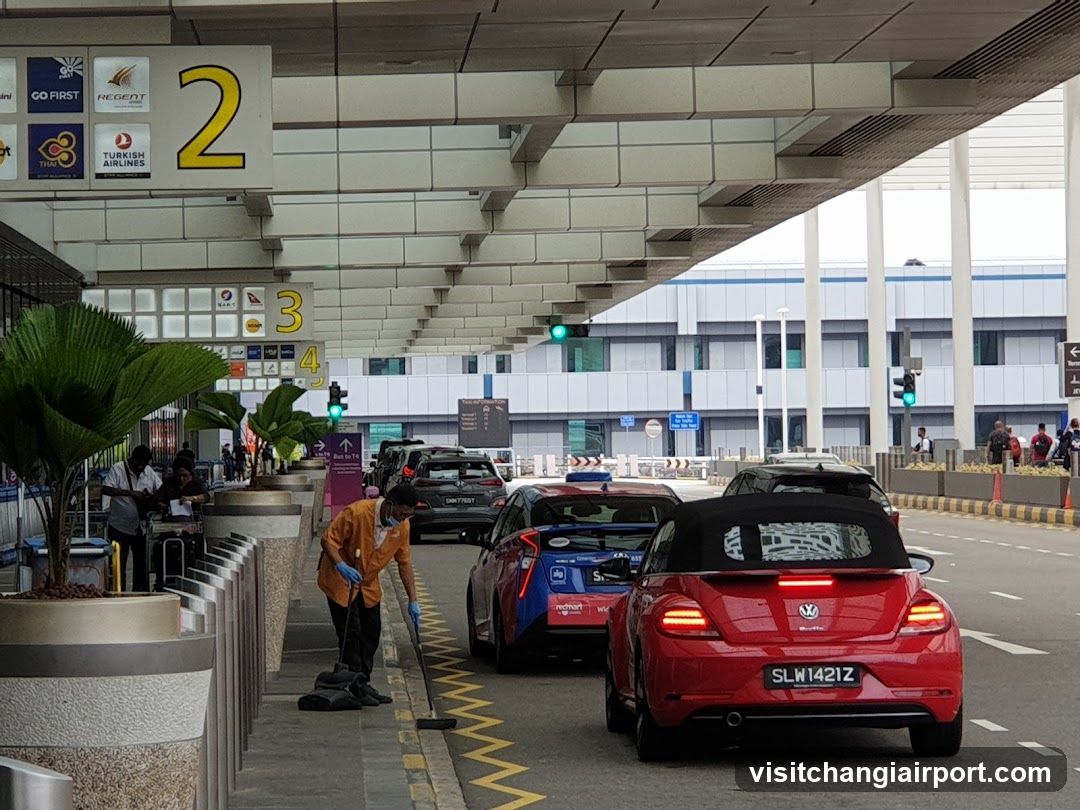 Airport Terminal Exterior with Vehicles and Staff