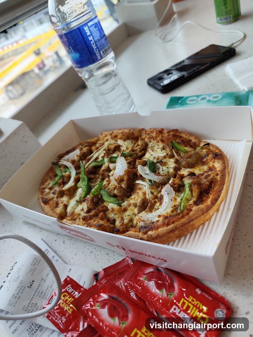 Pizza with condiments and water bottle