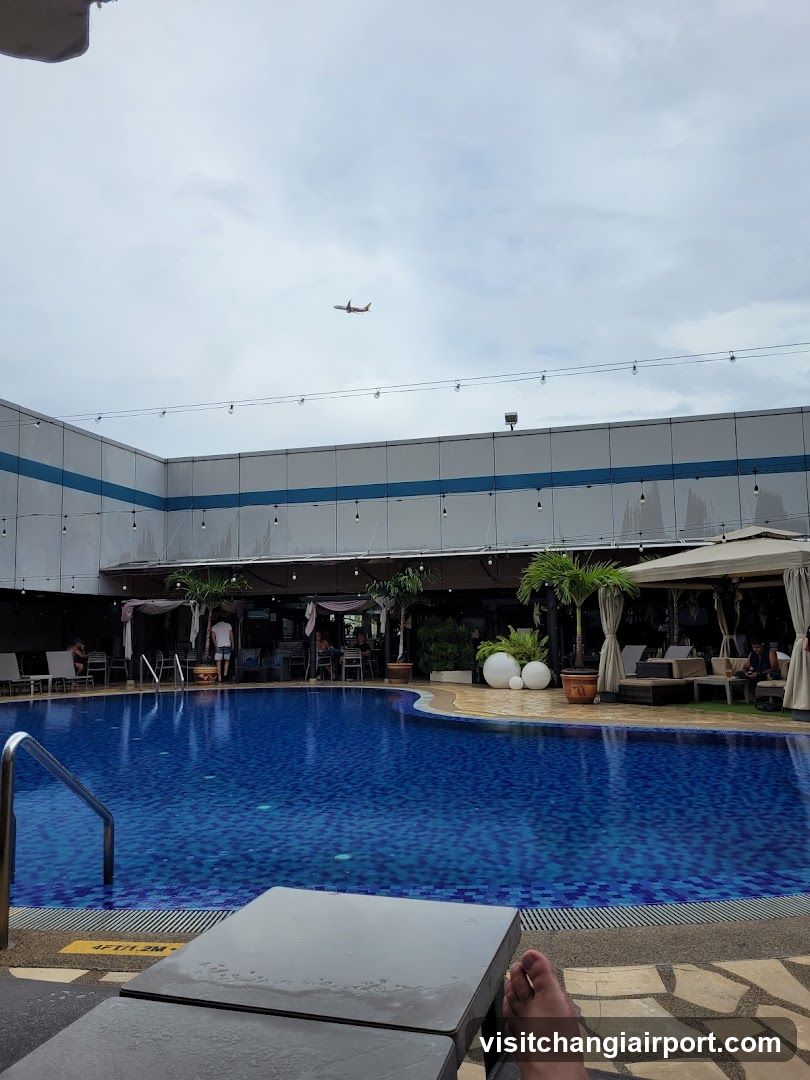 Poolside View with Airplane in Sky