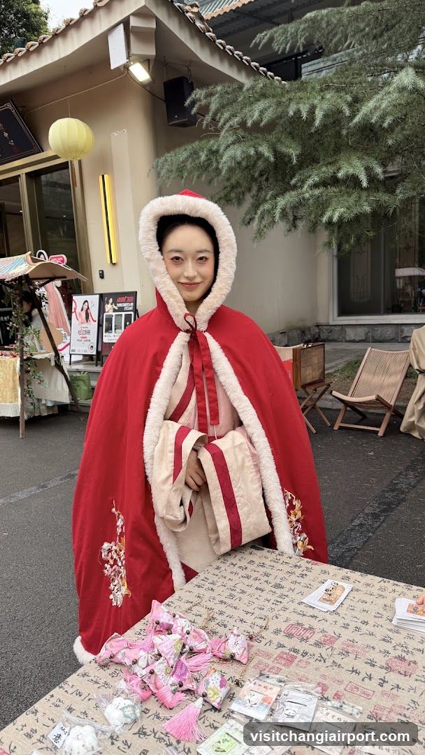 Red Cloak Model at Market Stall