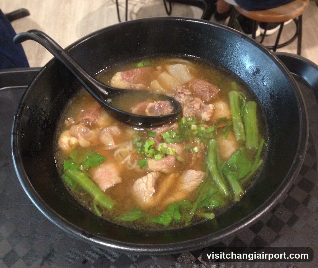 Bowl of Noodle Soup with Meat and Greens