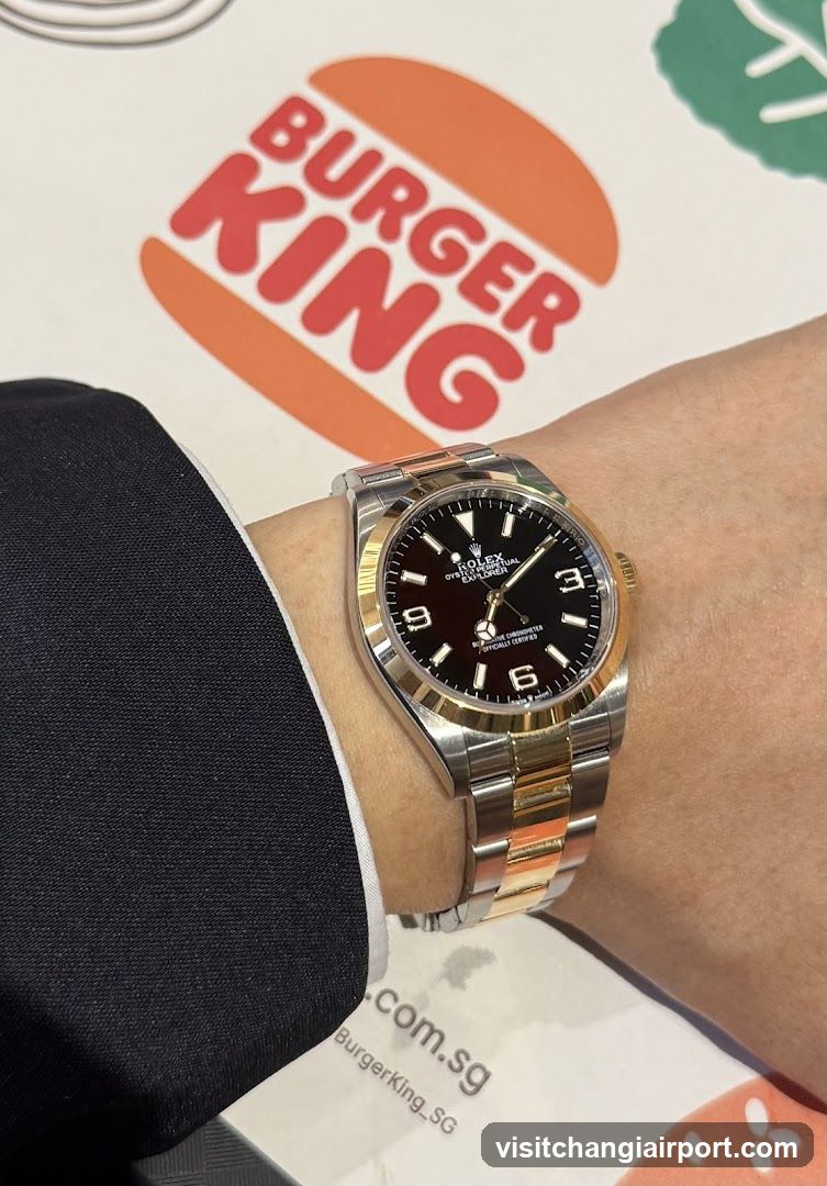 Rolex watch on wrist with Burger King background