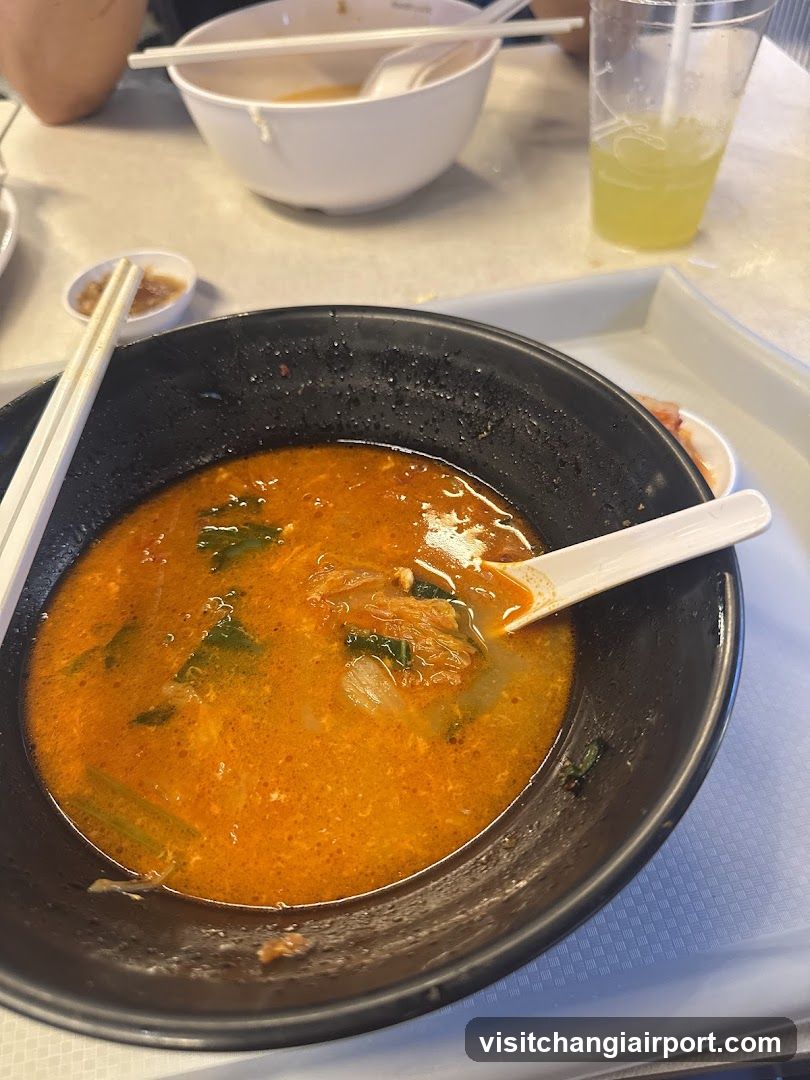 Bowl of Spicy Soup with Chopsticks and Spoon