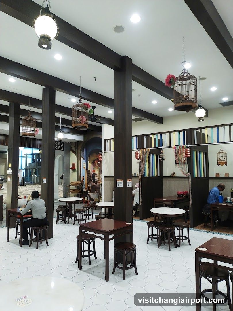 Interior of a restaurant with wooden furniture and hanging birdcages