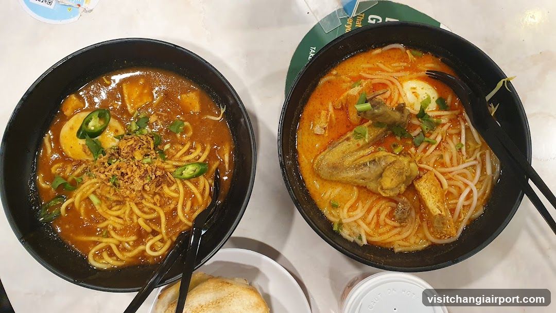 Two bowls of spicy noodles with chicken and egg