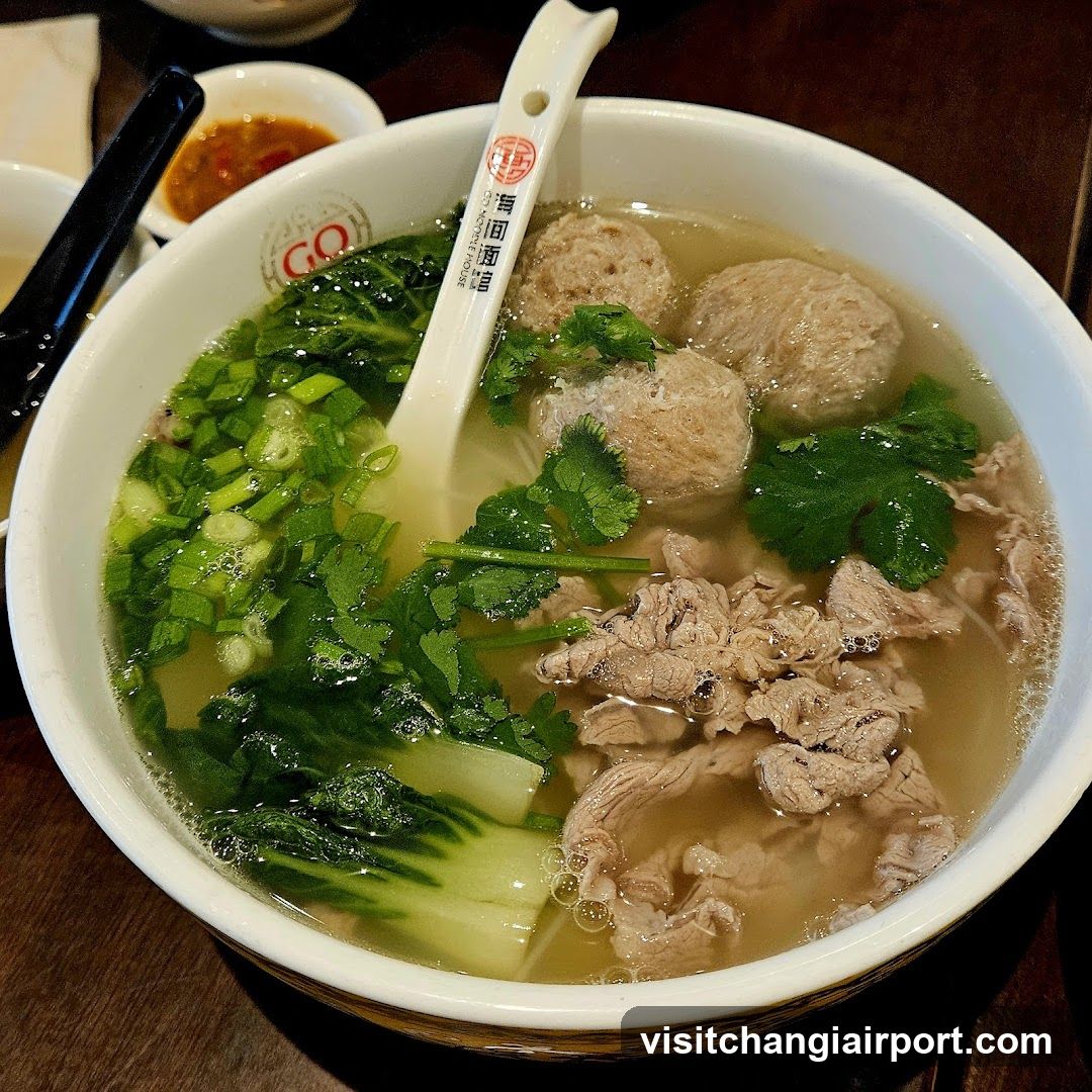 Bowl of Meatball Soup with Greens and Cilantro