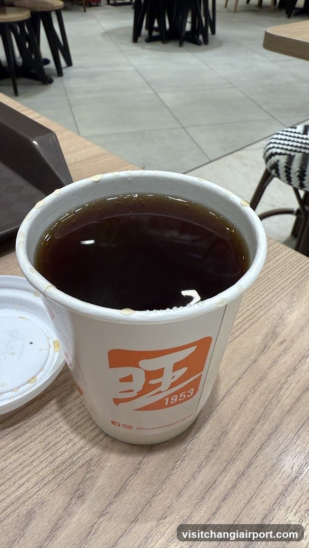 Cup of dark beverage on table