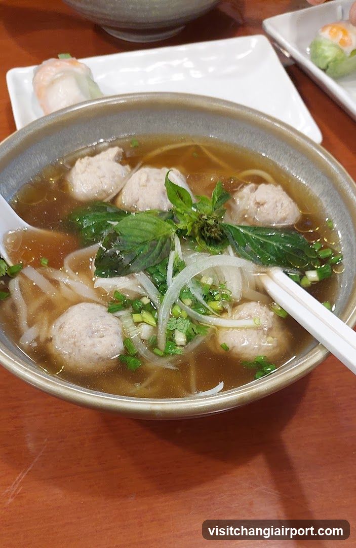 Bowl of Noodle Soup with Meatballs and Basil