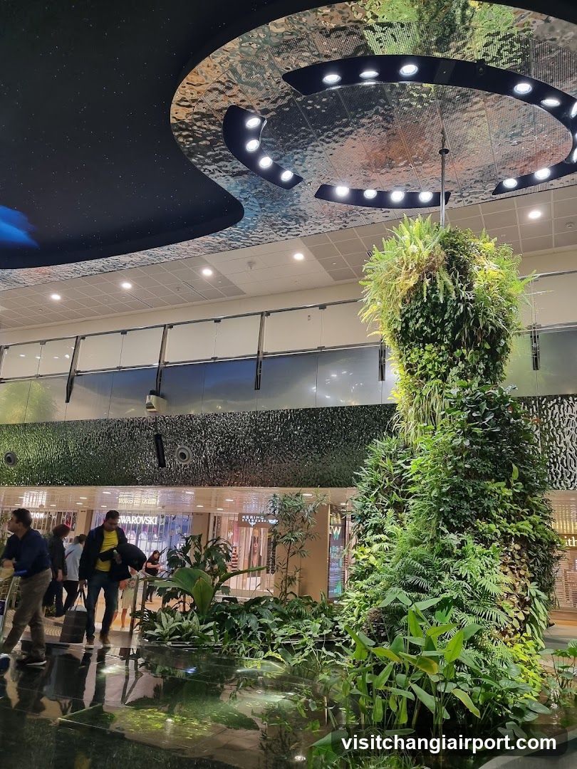 Jungle-themed indoor space with vertical garden and ceiling art