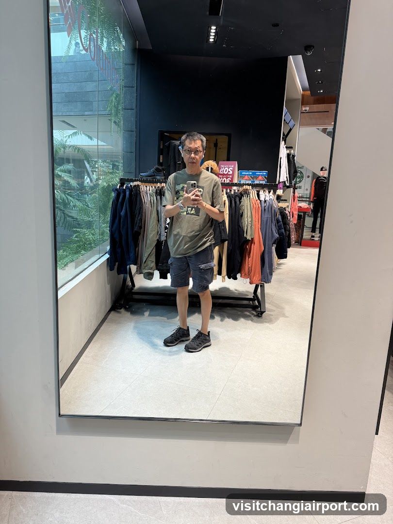 Man taking mirror selfie in clothing store