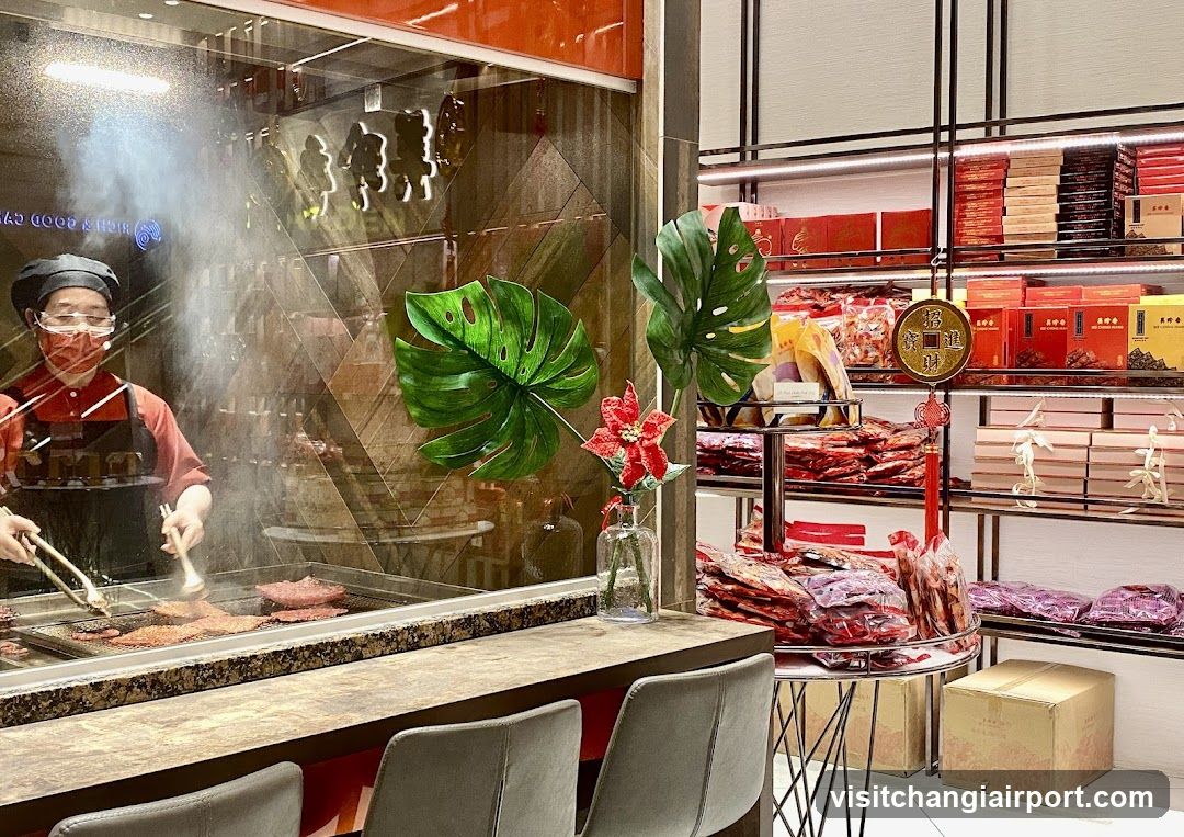 Food stall interior with staff cooking and packaged goods display