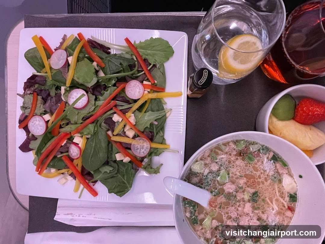 Aerial view of a meal tray with salad, soup, and fruit