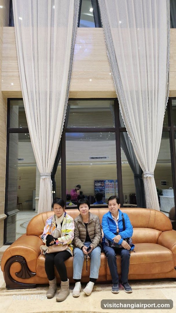 Three people sitting on a sofa in a lobby