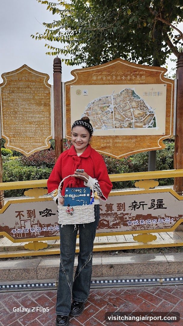 Woman in red coat standing before a signboard